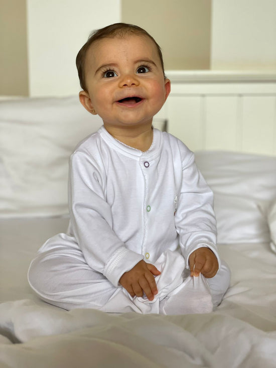 bebê com macacão em algodão pima sentada sorrindo